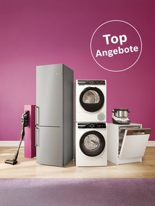 Eine moderne Küchenausstellung mit einem silbernen Kühlschrank, einer übereinander angeordneten Waschmaschine und einem Trockner, einem Geschirrspüler, einem Kochgerät und einem Staubsauger vor einer rosa Wand. Text „Top-Angebote“.