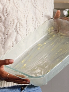 Empty baking glass tray with leftover cheese from baked-on mac-and-cheese