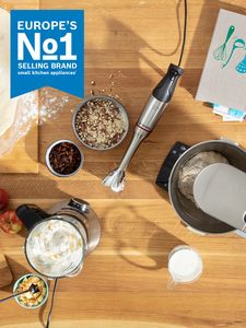 Overhead view of different food dishes sat on table, with Europe's Number 1 Brand Food Preparation Appliances icon