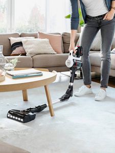 Bosch vacuum cleaner being used under coffee table in living room