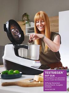 Eine l&auml;chelnde Frau gibt Zutaten in die Bosch Cookit K&uuml;chenmaschine in einer modernen K&uuml;che.