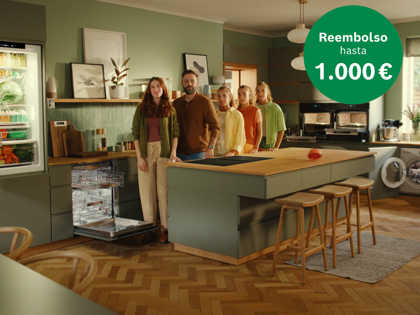 Cocina con isla y electrodom&eacute;sticos Bosch (frigor&iacute;fico, lavavajillas abierto, hornos, lavadora); cinco personas y sello "Reembolso hasta 1.000 &euro;".