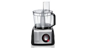 A black and silver MultiTalent 8 food processor chopping green vegetables.