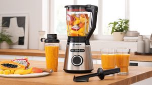 Bosch Blender VitaPower Series 4 with fruits, To-Go-bottle and smoothie glasses on a kitchen shelf.