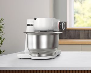 Weiße Küchenmaschine Serie 2 auf einer Arbeitsplatte aus Holz.