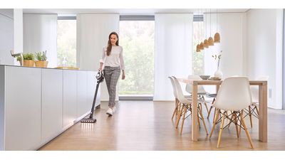 Person using vacuum cleaner on laminate floor