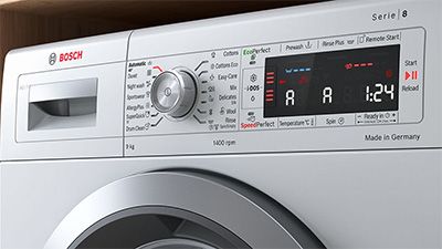 Nahaufnahme des Bedienfeldes einer Bosch Waschmaschine in einem eleganten, modernen Design. Auf der Digitalanzeige werden Symbole dargestellt. 