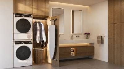 Moderna lavanderia con lavatrice, asciugatrice, armadi in legno e impianto in vaso. 