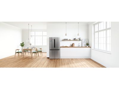 Modern open kitchen with freestanding french door fridge in the corner.