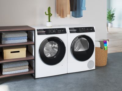 Bosch freestanding washer next to condense dryer in a modern laundry room.