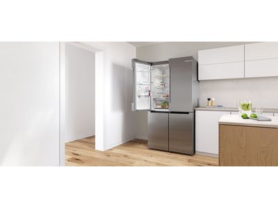 Modern open kitchen with freestanding french door fridge in the corner.