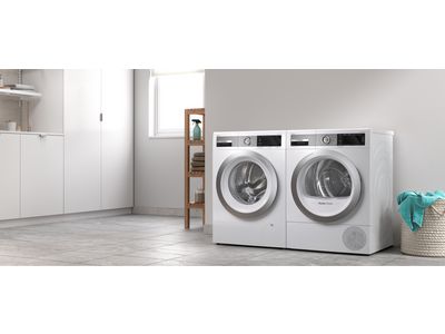 Lavatrice e asciugatrice Bosch da libero posizionamento in una lavanderia bianca dallo stile moderno.