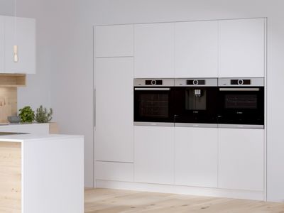 A built in steam oven in a white kitchen.