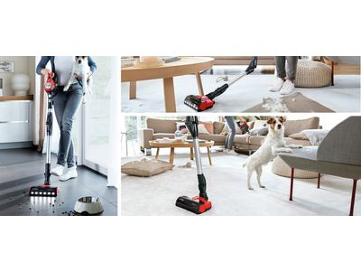 A lineup of four different vacuum cleaners in a bright hallway.