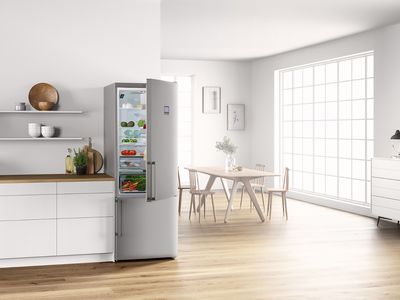 Réfrigérateur-congélateur en acier inoxydable dans une cuisine moderne et lumineuse.
