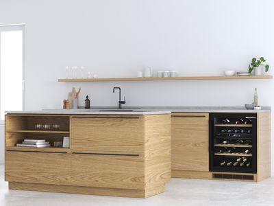 Wijnkast met led-verlichting, ingebouwd in een modern eiken meubel in een minimalistische keuken.