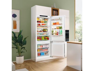 Open light kitchen with built-in fridge freezer showing inside contents