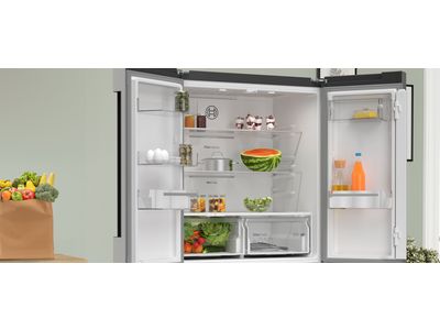 Modern open kitchen with freestanding french door fridge in the corner.