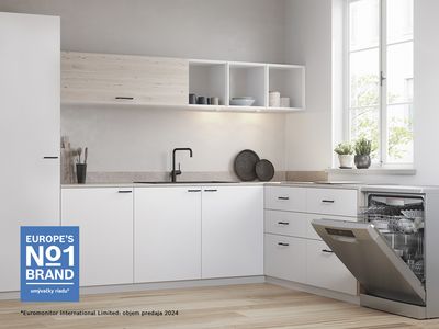 Otvorená voľne stojaca umývačka riadu v bielej a svetlej kuchyni.