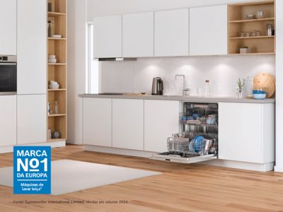 uma m&aacute;quina de lavar loi&ccedil;a de integrar aberta numa cozinha branca moderna.