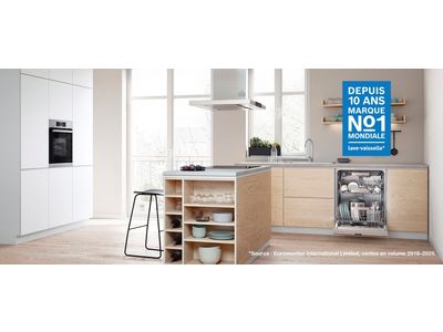 Une cuisine blanche et bois avec un appareil &eacute;lectrom&eacute;nager rempli et ouvert.