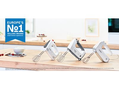 Collection de trois mixeurs batteur Bosch sur un plan de travail de cuisine en bois.