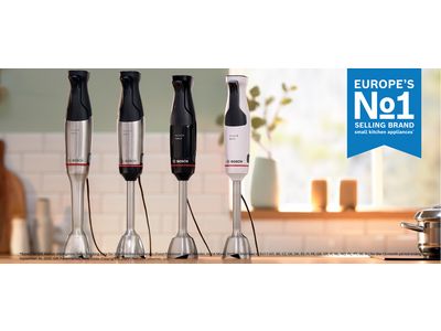 Een paar staafmixers van Bosch op een houten aanrecht in een lichte, open keuken.