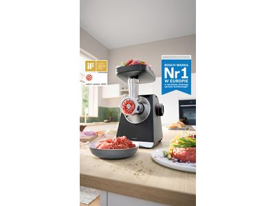MultiPower Serie 6 z przystawką do mielenia i mięsem na tacy na blacie kuchennym obok talerza z kawałkami mięsa.