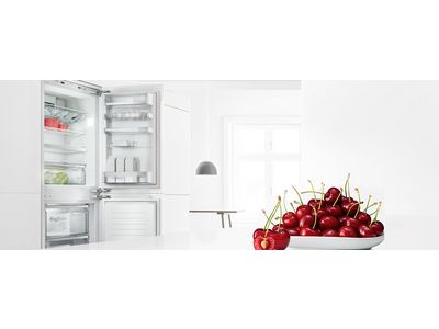 Stainless steel fridge freezer in a bright, modern kitchen.