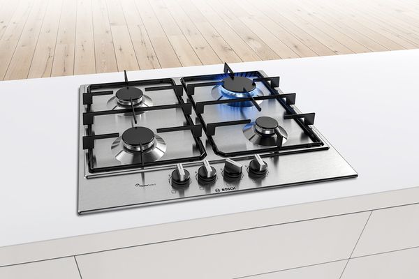 A Bosch Series 6 stainless steel gas hob fitted in the centre of a narrow white island.
