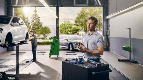 Man Cleaning Parts In Car Garage