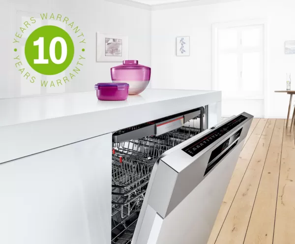Bosch built-in dishwasher in a modern kitchen flooded with light. Free anti-rust extended warranty is represented by the green 10-year warranty icon.