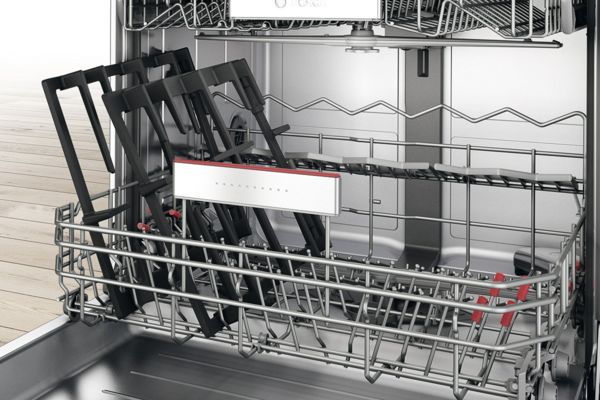 Open Bosch dishwasher containing dishwasher-proof pan supports from a gas hob to show easy cleaning.