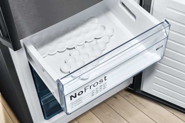 Nahaufnahme einer Bosch-Schublade mit zwei Eiswürfelschalen stellt dar, was NoFrost bedeutet.