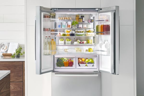 Frigo-congelatore a tre porte (french door) aperto, pieno di alimenti deliziosi e bevande.