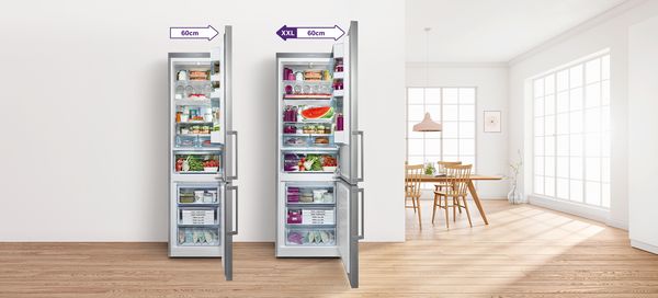 Jedan veliki otvoreni kombinovani frižider sa zamrzivačem od 70 cm pored samostojećeg kombinovanog frižidera sa zamrzivačem od 60 cm.  Oba su napunjena svežim namirnicama.    