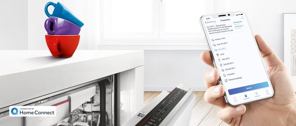 Home Connect App mit Geschirrspülerprogrammen, Geschirrspüler von Bosch im Hintergrund. 
