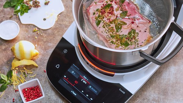 Ein Bosch Cookit steht neben frischen Zutaten auf einer Küchenarbeitsplatte.