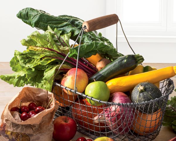 Cestino della spesa pieno di verdure e frutta fresche e genuine