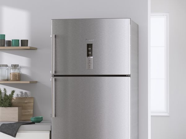 Freestanding stainless steel fridge with top freezer and temperature monitor at eye level