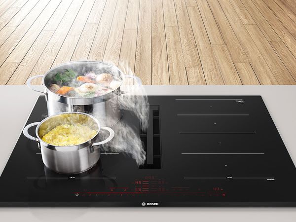 Steaming pots on an induction hob with an integrated ventilation module