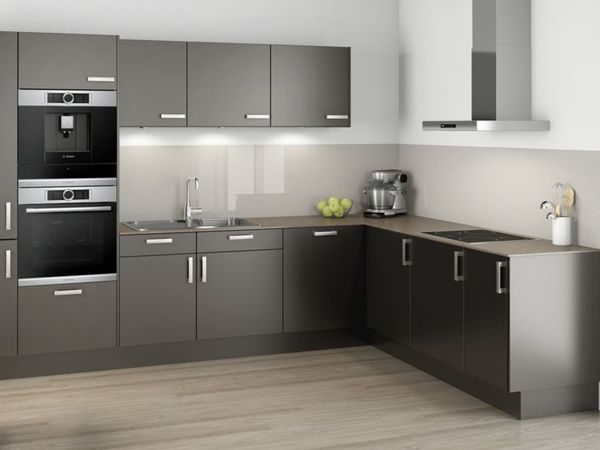 Bucătărie mică, modernă, în formă de L, cu fronturi de dulap de culoarea grafitului plus un frigider încorporabil și electrocasnice de gătit