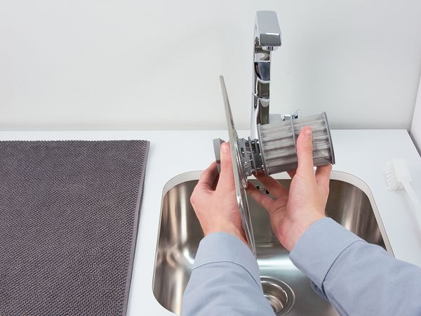 Image montrant deux mains séparant l'unité de filtrage d'un lave-vaisselle Bosch