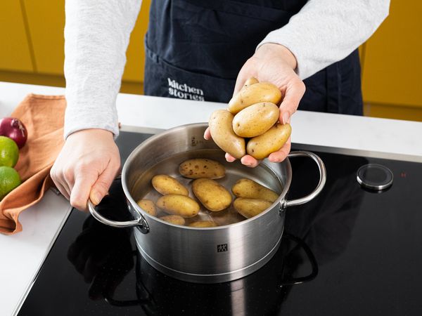 Placing potatoes in a steel saucepan on an induction hob