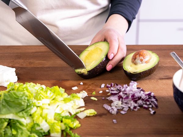 Chopping vegetables such as red onion, avocado and lettuce