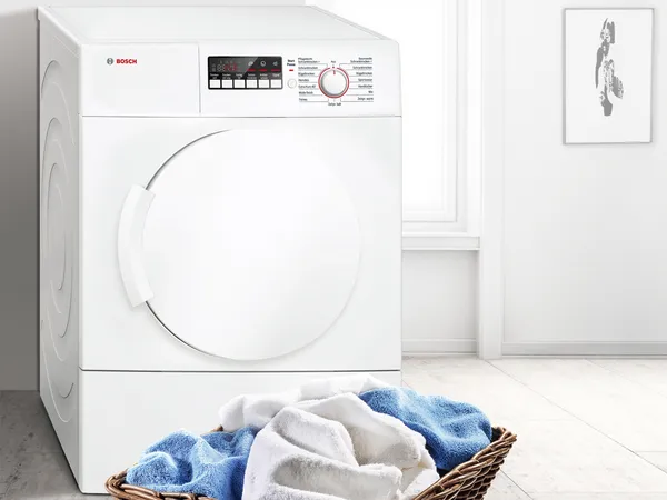White tumble dryer with clothes