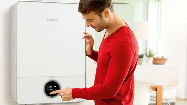 En mann kontrollerer en Bosch varmtvannbeholder