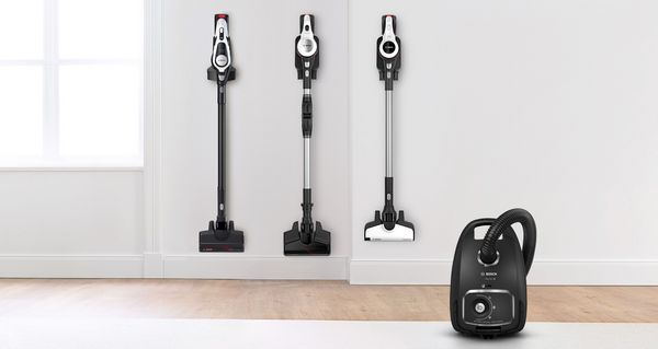 Multiple vacuum cleaners against plain walled living room