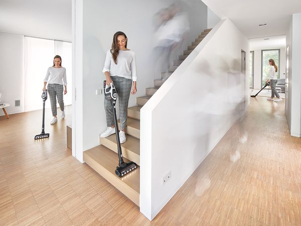 The same woman vacuums with a Bosch Unlimited vacuum cleaner in 3 different places at the same time, symbolizing the different tasks a Bosch battery can handle 