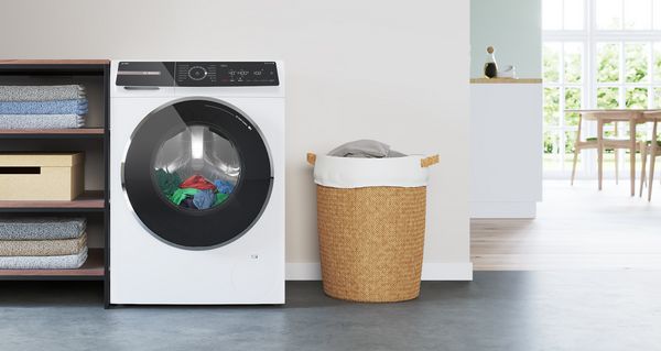 Отдельно стоящая стиральная машина Bosch в современной белой ванной комнате